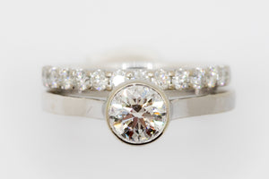 An image of a round brilliant cut diamond ring with an eternity band by Bexon Jewelry.
