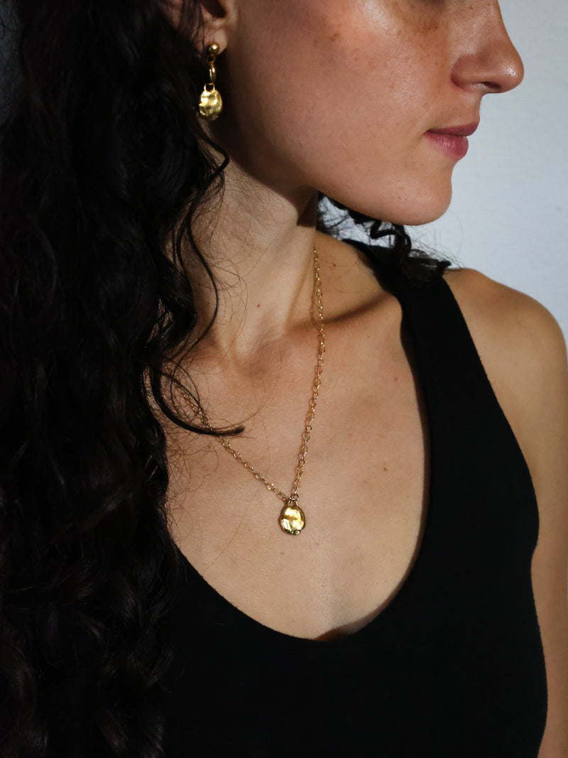 A Model Wears the Mollitia Medallion Necklace and Rem Drop Earrings in Gold Vermeil by Bexon Jewelry 