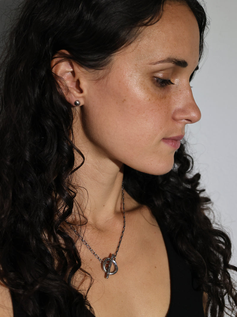 A model wearing the Vox toggle necklace in recycled sterling silver by Bexon Jewelry 