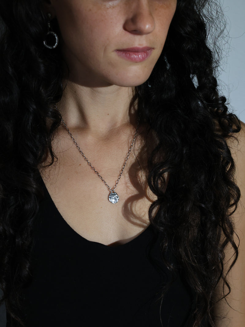 A model wears the Mollitia Medallion Necklace in recycled sterling silver by Bexon Jewelry
