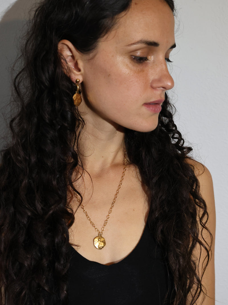 A model wears the Restituo Medallion in Gold vermeil by Bexon Jewelry