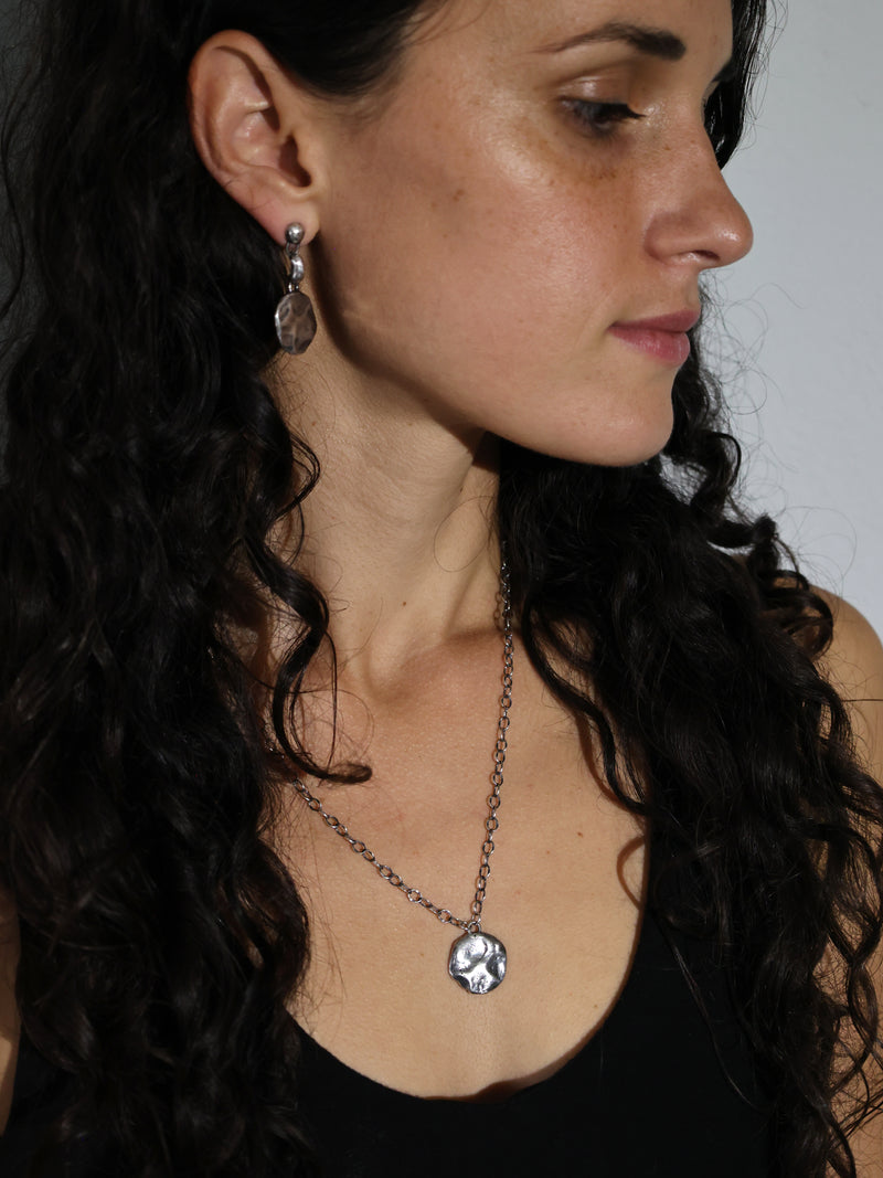 A model wears the Restituo Medallion Necklace in Recycled Sterling Silver by Bexon Jewelry
