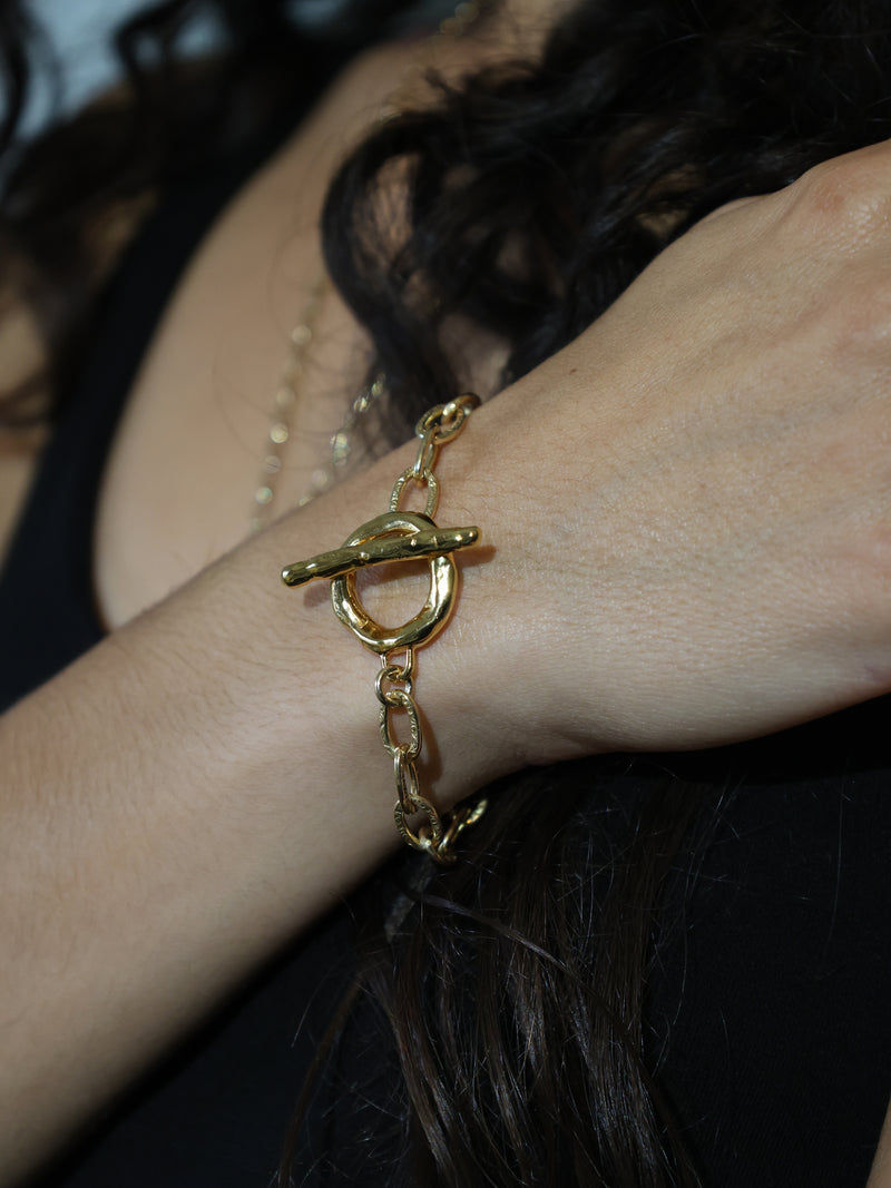 A models wrist with the Vires toggle bracelet in gold vermeil by Bexon Jewelry 