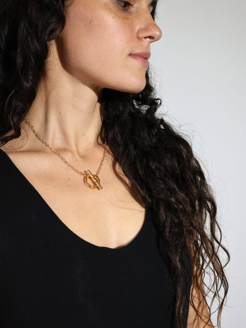 A model wearing the Vox Toggle necklace in gold vermeil by Bexon Jewelry