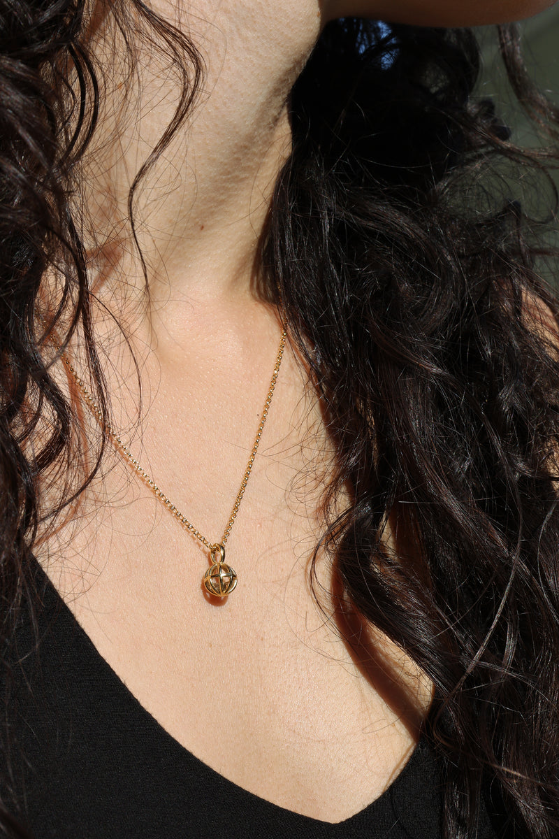 A model wears a  gold necklace with a rough diamond by Bexon Jewelry